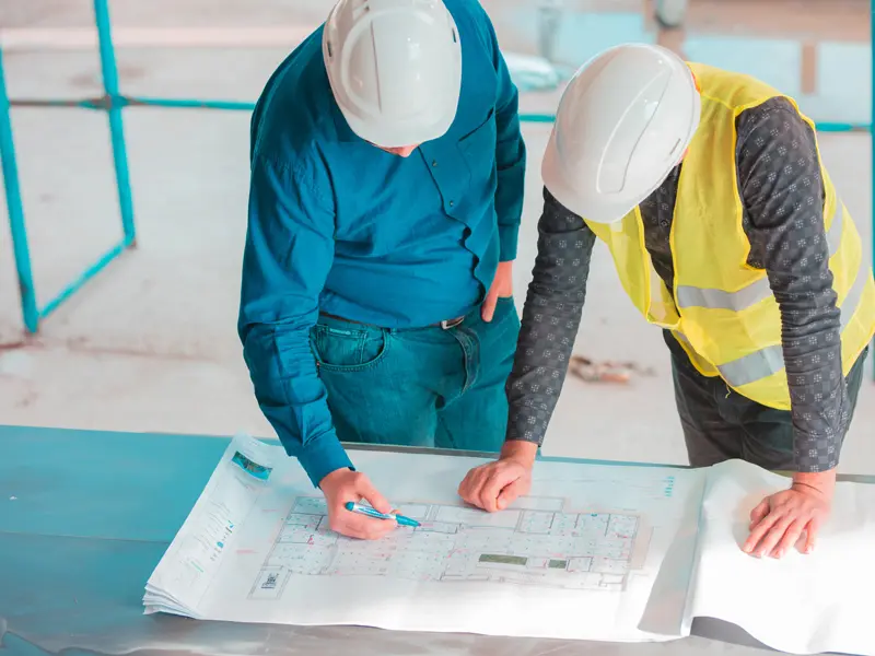 Engineers reviewing construction drawings and project plans for infrastructure engineering works by Osool AlRoyah in the UAE