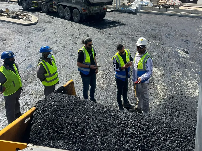 Engineers inspecting asphalt road construction work at a project site by Osool AlRoyah General Contracting in the UAE